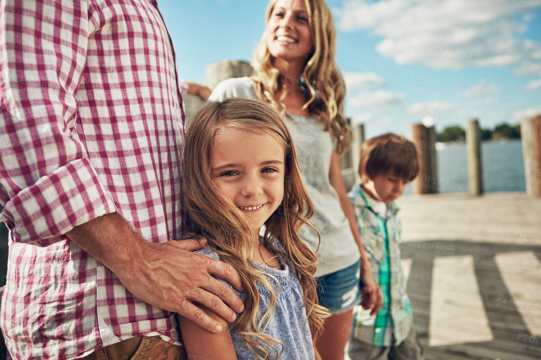 Buy stock photo Shot of a young family on a pier while out by the lake