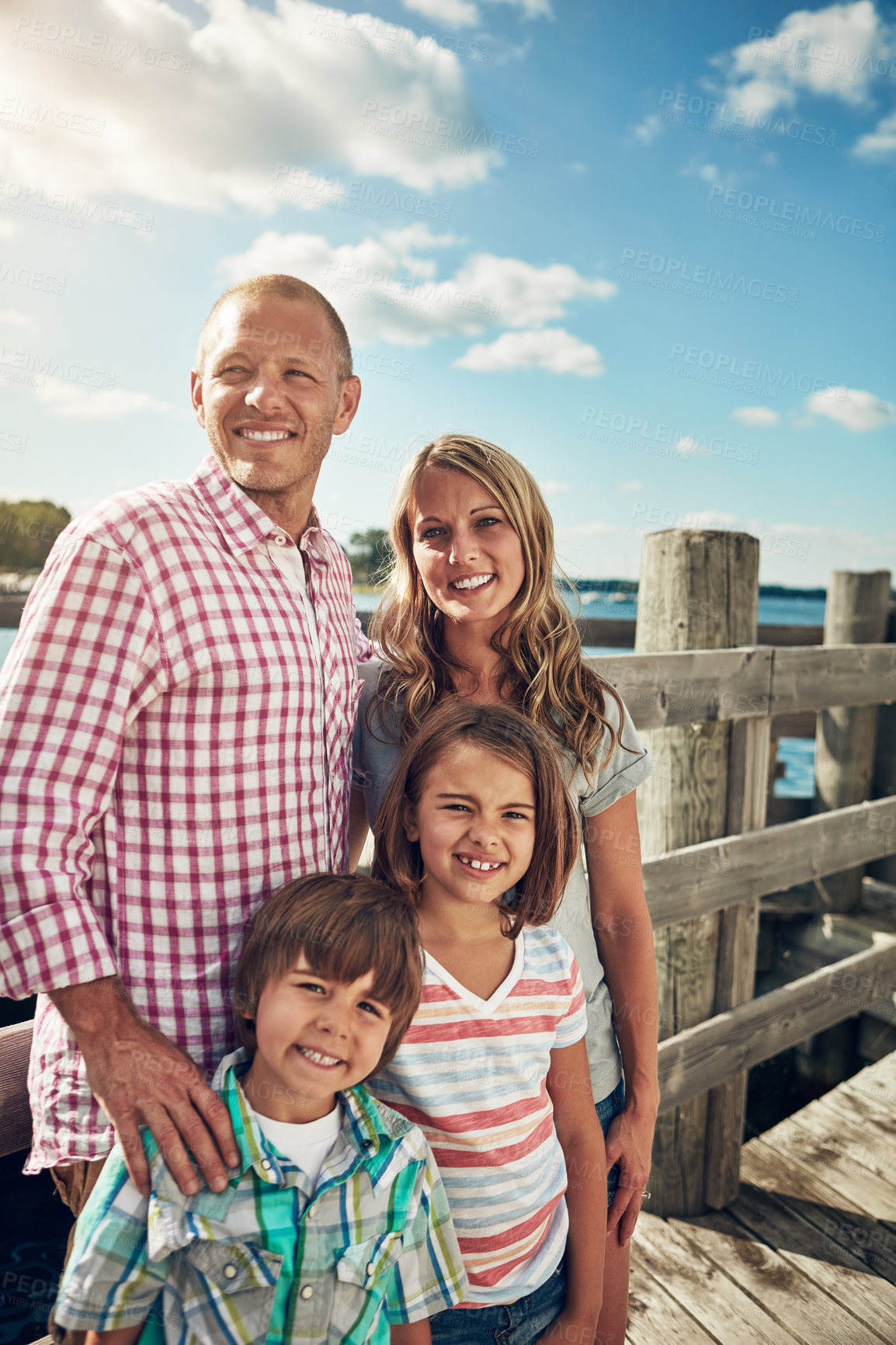 Buy stock photo Shot of a young family on a pier while out by the lake