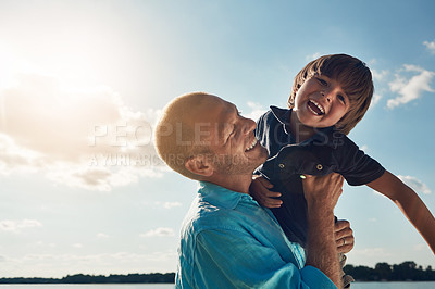 Buy stock photo Shot of a middle-aged man and his young son spending some quality time at the beach