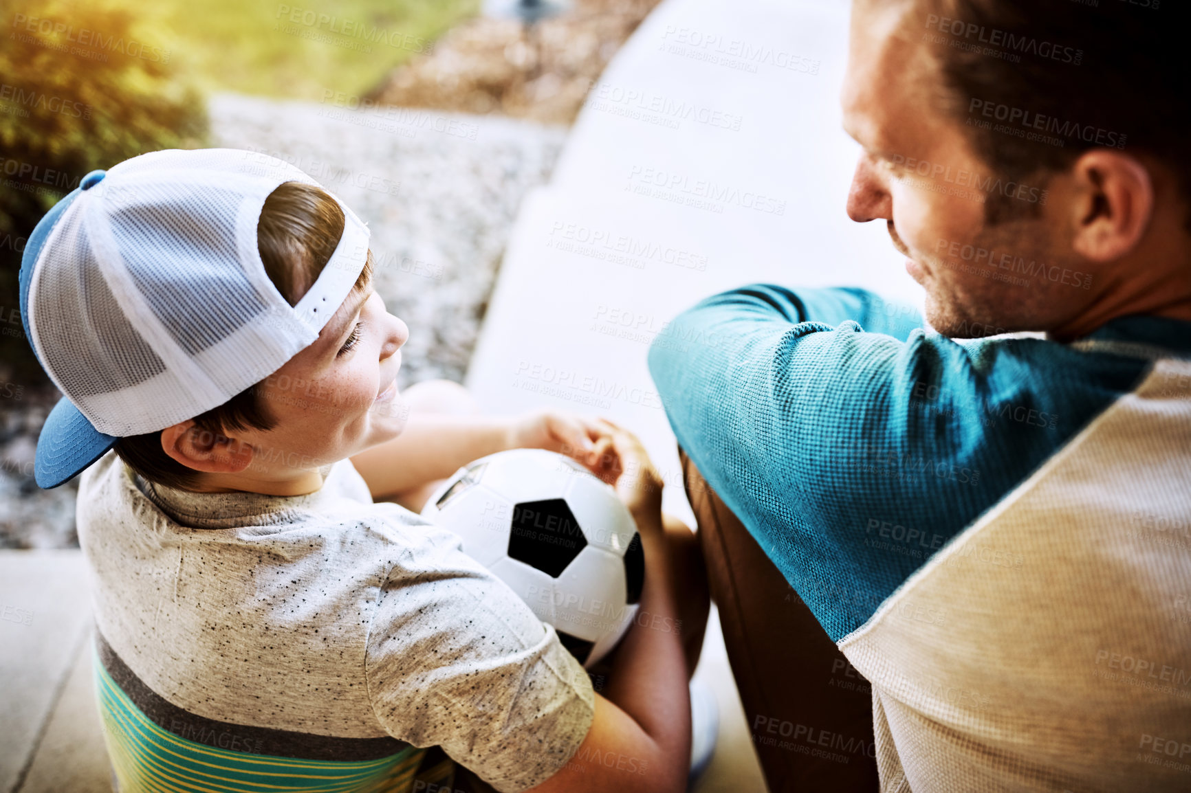 Buy stock photo Dad, son and relax with soccer ball in backyard for outdoor sports, break and fun in child development. Happy, man and kid outside home with smile for exercise, practice and bonding on fathers day