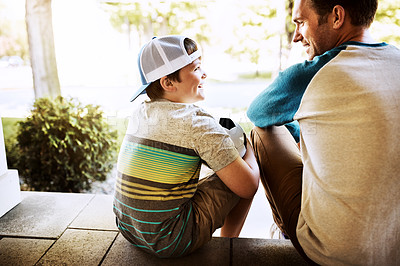 Buy stock photo Rearview shot of a father and his son bonding on their porch at home
