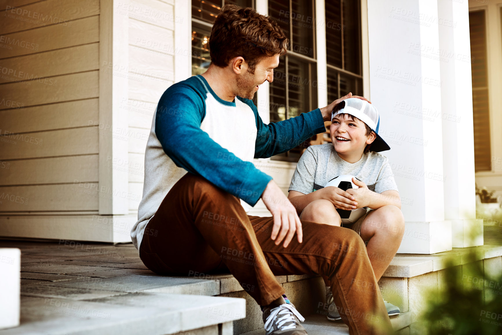 Buy stock photo Shot of a father and his son bonding on their porch at home