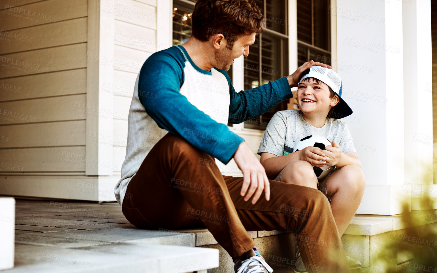 Buy stock photo Shot of a father and his son bonding on their porch at home