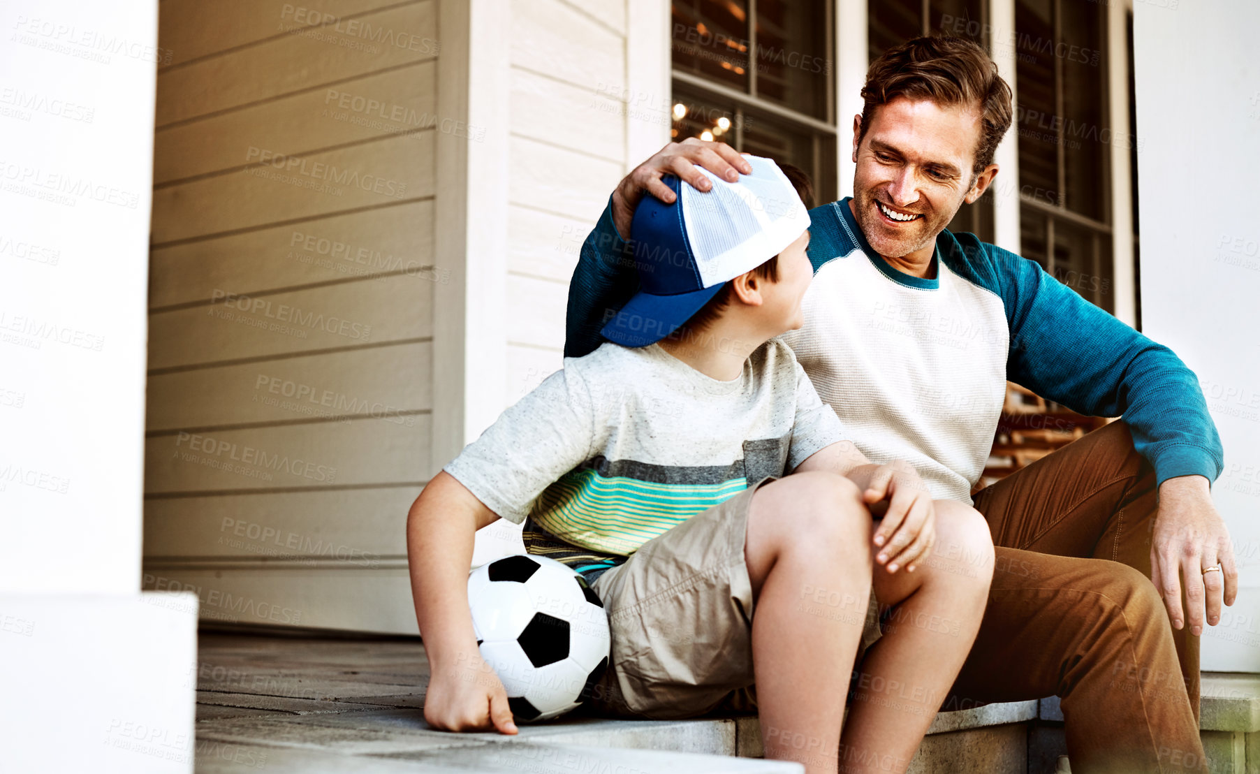 Buy stock photo Shot of a father and his son bonding on their porch at home