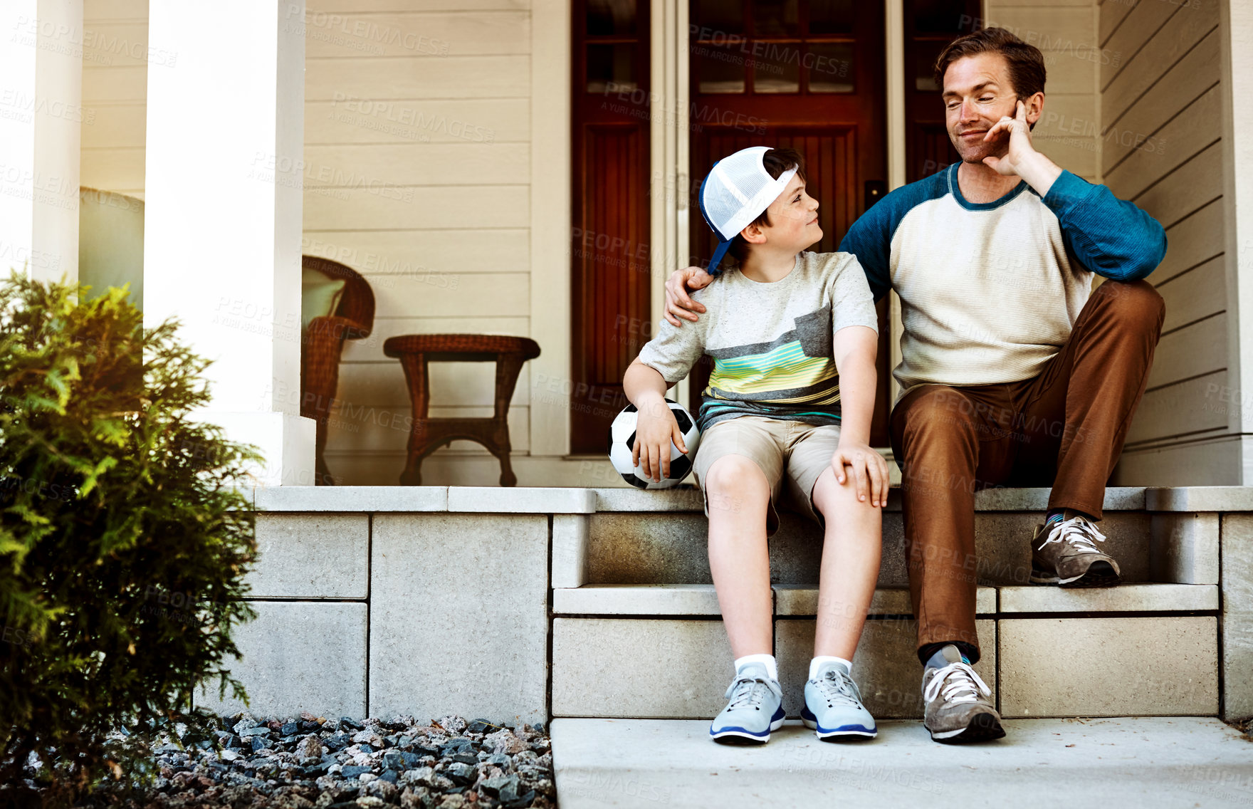 Buy stock photo Shot of a father and his son bonding on their porch at home