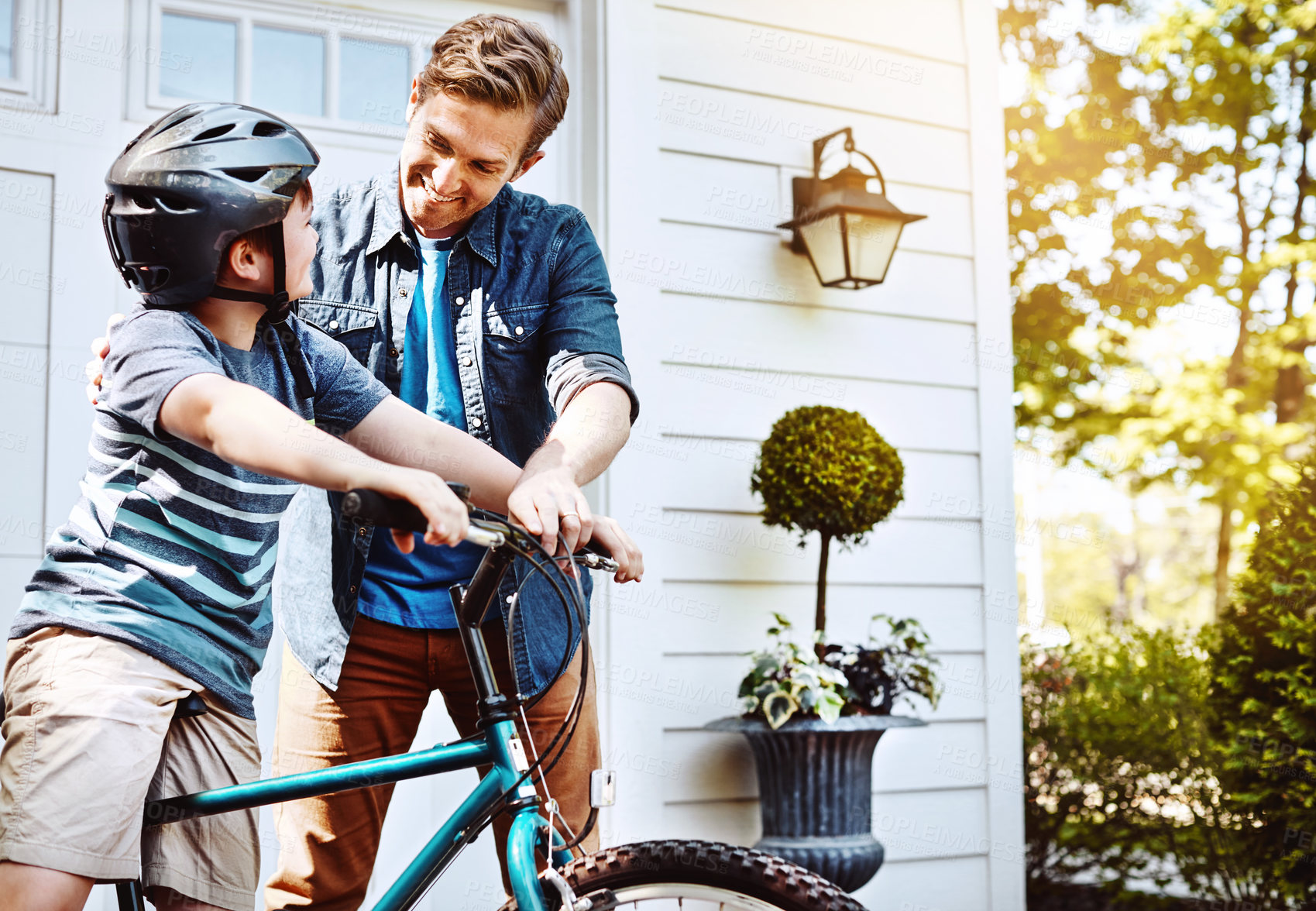 Buy stock photo Shot of a father teaching his son how to ride a bicycle