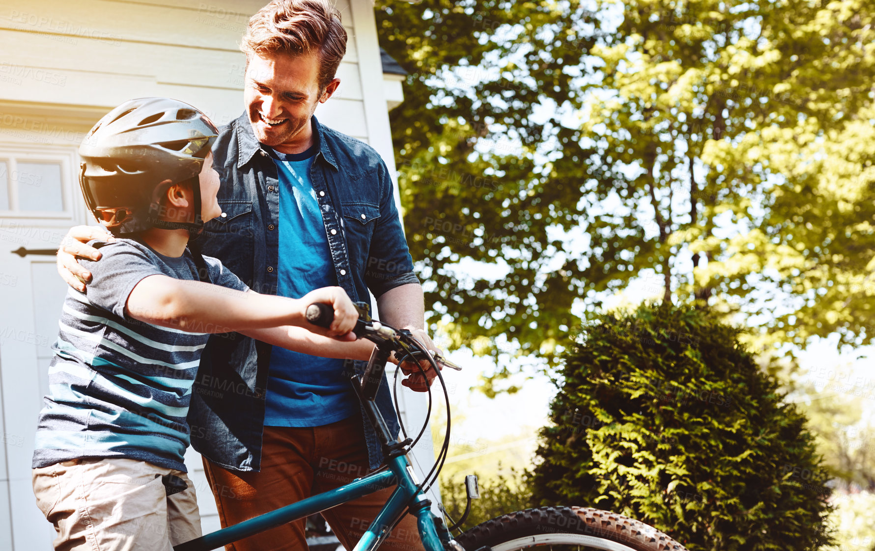 Buy stock photo Shot of a father teaching his son how to ride a bicycle