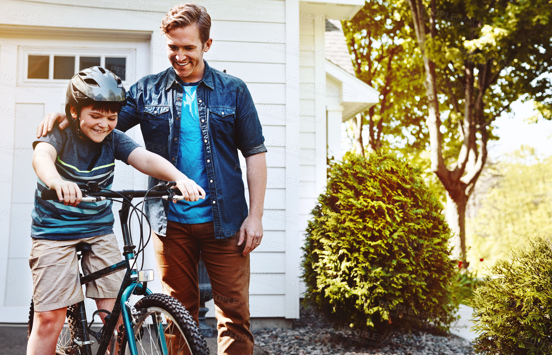 Buy stock photo Shot of a father teaching his son how to ride a bicycle