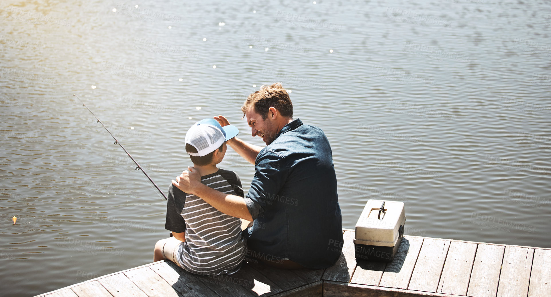 Buy stock photo Father, back and bonding with son or fishing rod by lake, ocean or beach together in nature. Man with young child, kid or little boy with hug for lesson or tips to catch sea creatures by water