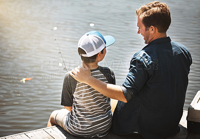 Buy stock photo Rear view shot of a father and his little son fishing together