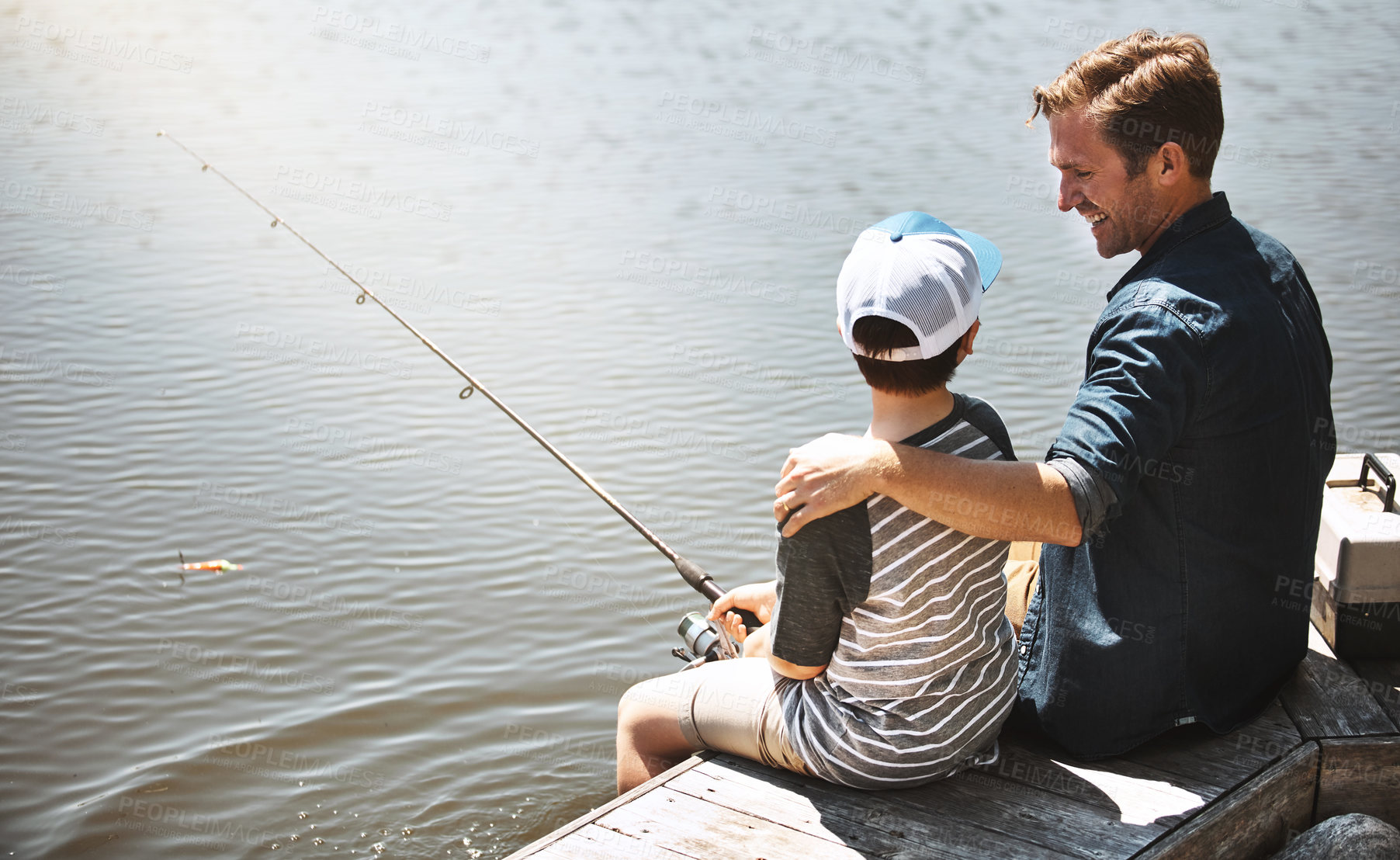 Buy stock photo Happy dad, hug and fishing lesson with son or rod by lake, ocean or beach together in nature. Father with child, young kid or little boy with smile for bonding or teaching tips to catch by sea water