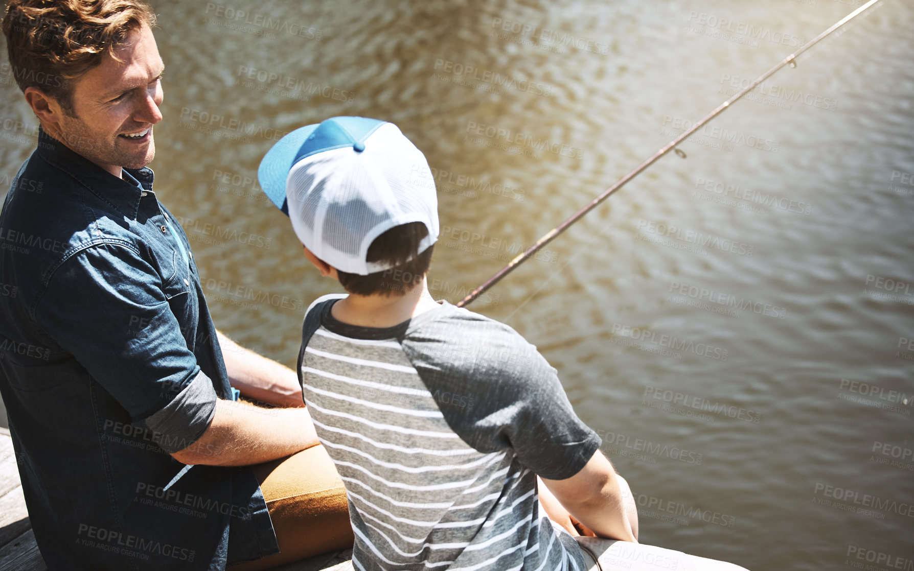 Buy stock photo Happy father, son and fishing lesson with rod by lake, ocean or beach together in nature. Dad with child, young kid or little boy with smile for bonding, trick or teaching tips to catch by sea water