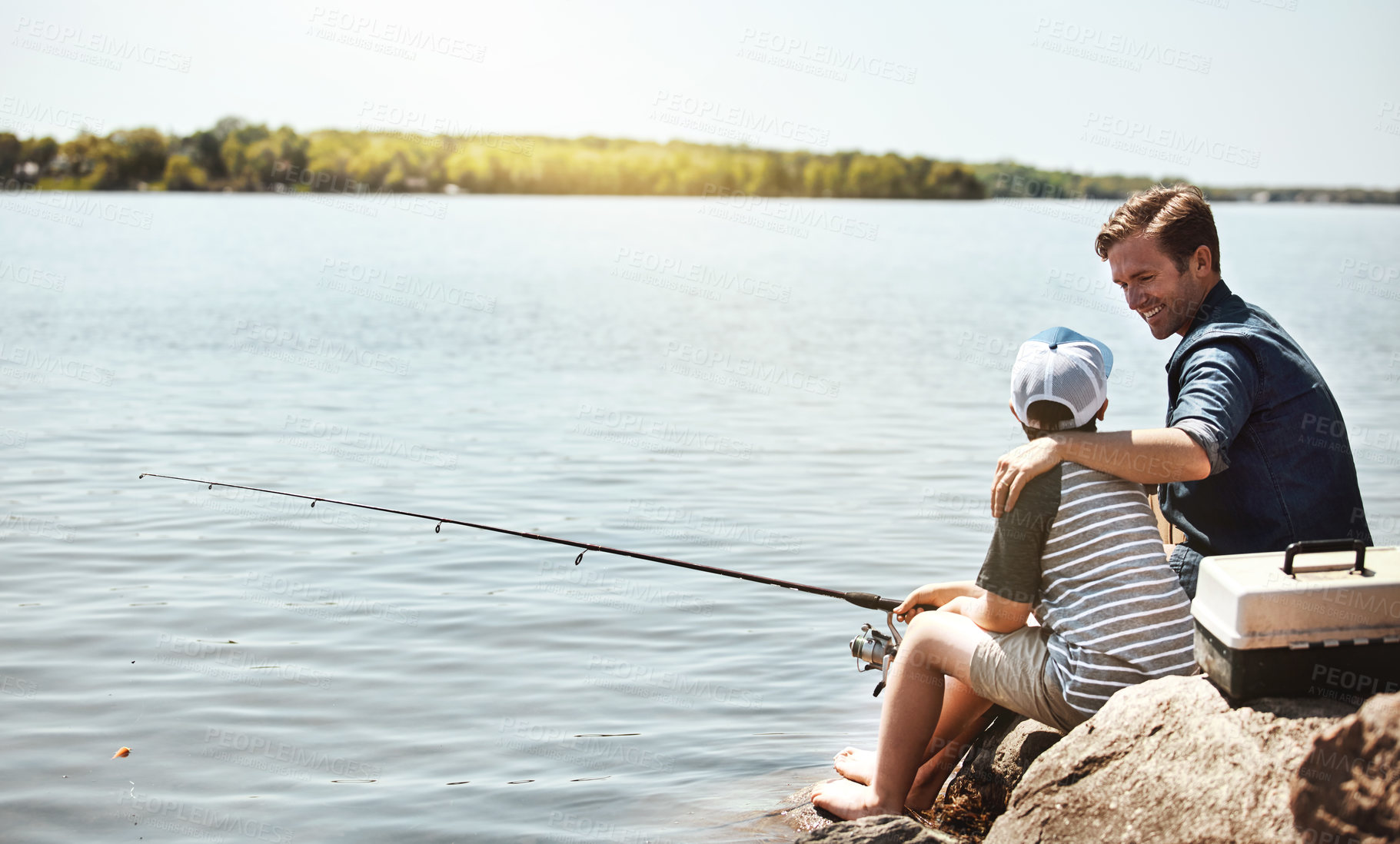 Buy stock photo Happy father, fishing and lesson with son on rock with rod by lake, ocean or beach together in nature. Dad with kid, young child or little boy for bonding, teaching or tips to catch by sea water