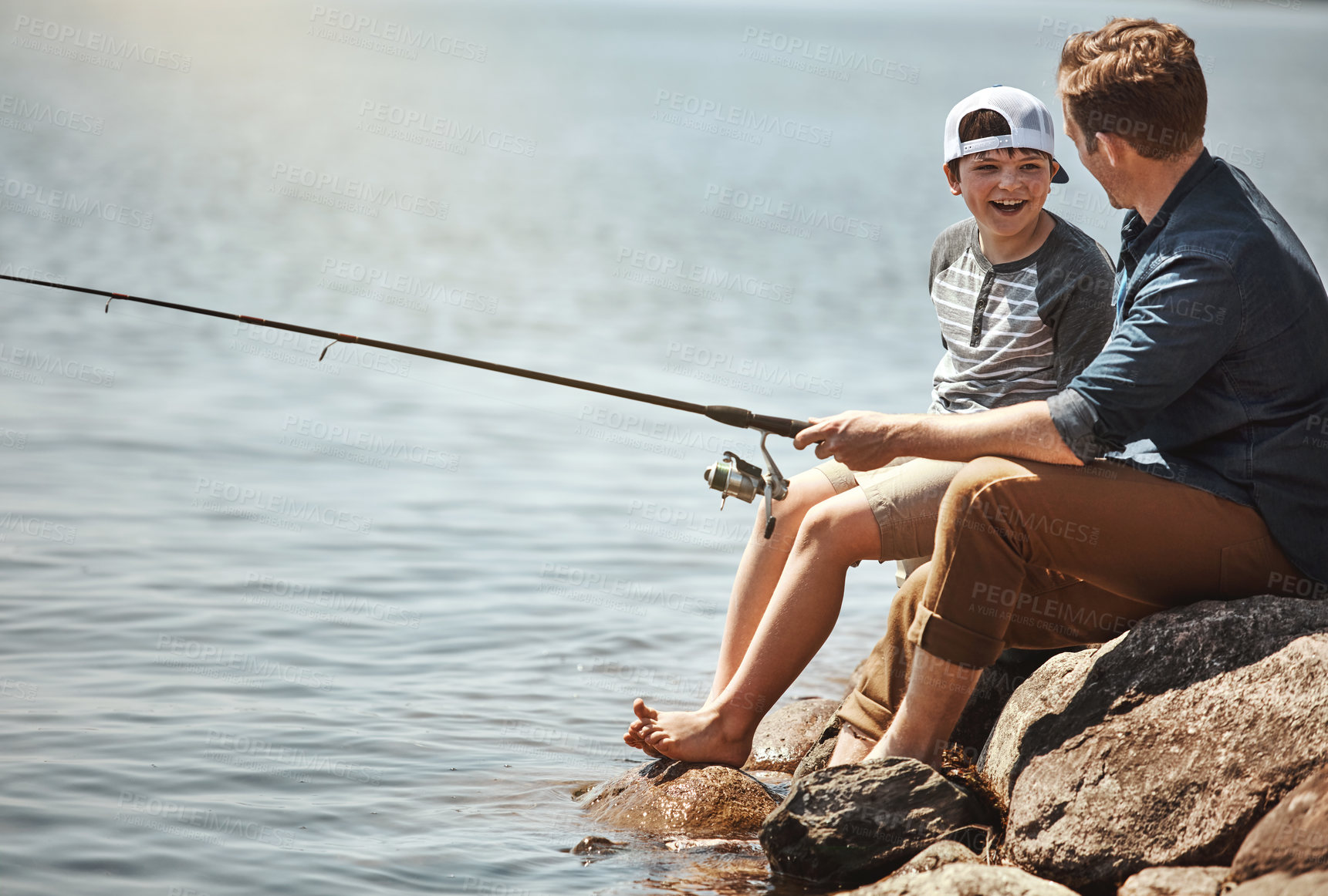 Buy stock photo Happy child, father and learning with fishing rod by lake, ocean or beach together in nature. Dad with son, young kid or little boy for bonding, teaching tips or lesson to catch by sea water