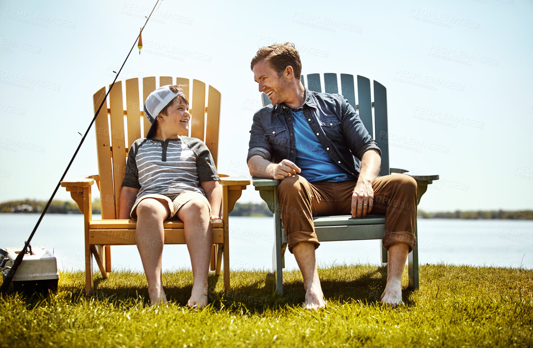 Buy stock photo Shot of a father and his little son enjoying a fishing trip together