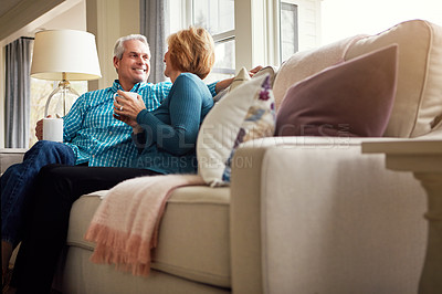 Buy stock photo Senior couple, tea and smile on sofa in conversation, relax or happy memory in home living room. Old man, elderly woman and chat for bonding with coffee, love or story in retirement on couch in house