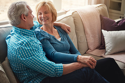 Buy stock photo Love, holding hands and senior couple relax on sofa with conversation, trust and support, care or bonding in their home together. Happy, calm and old people hug in living room with marriage pride