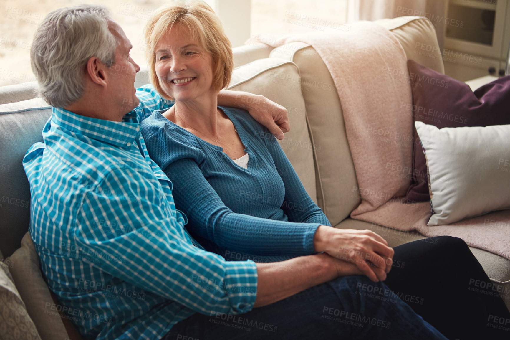 Buy stock photo Love, holding hands and senior couple relax on sofa with conversation, trust and support, care or bonding in their home together. Happy, calm and old people hug in living room with marriage pride