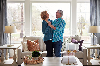 Buy stock photo Shot of a happy mature couple dancing together in their living room at home