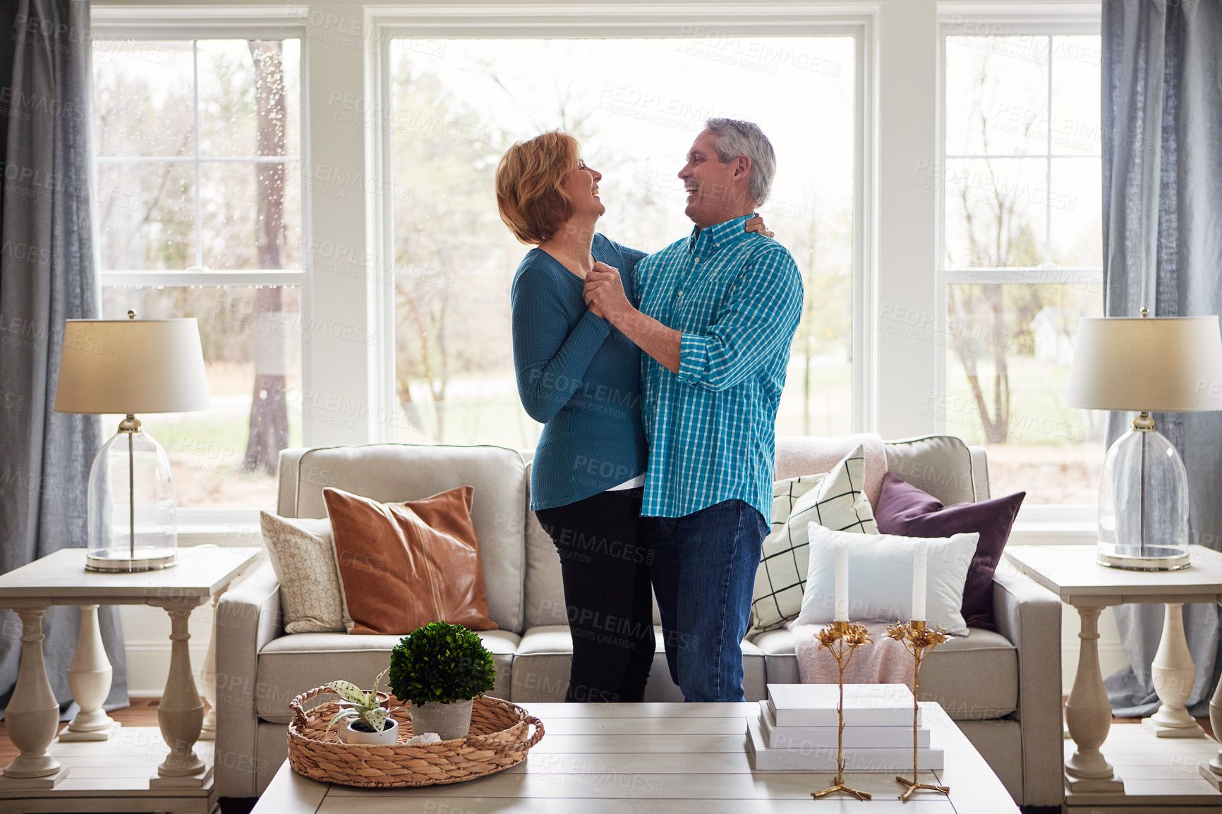 Buy stock photo Shot of a happy mature couple dancing together in their living room at home