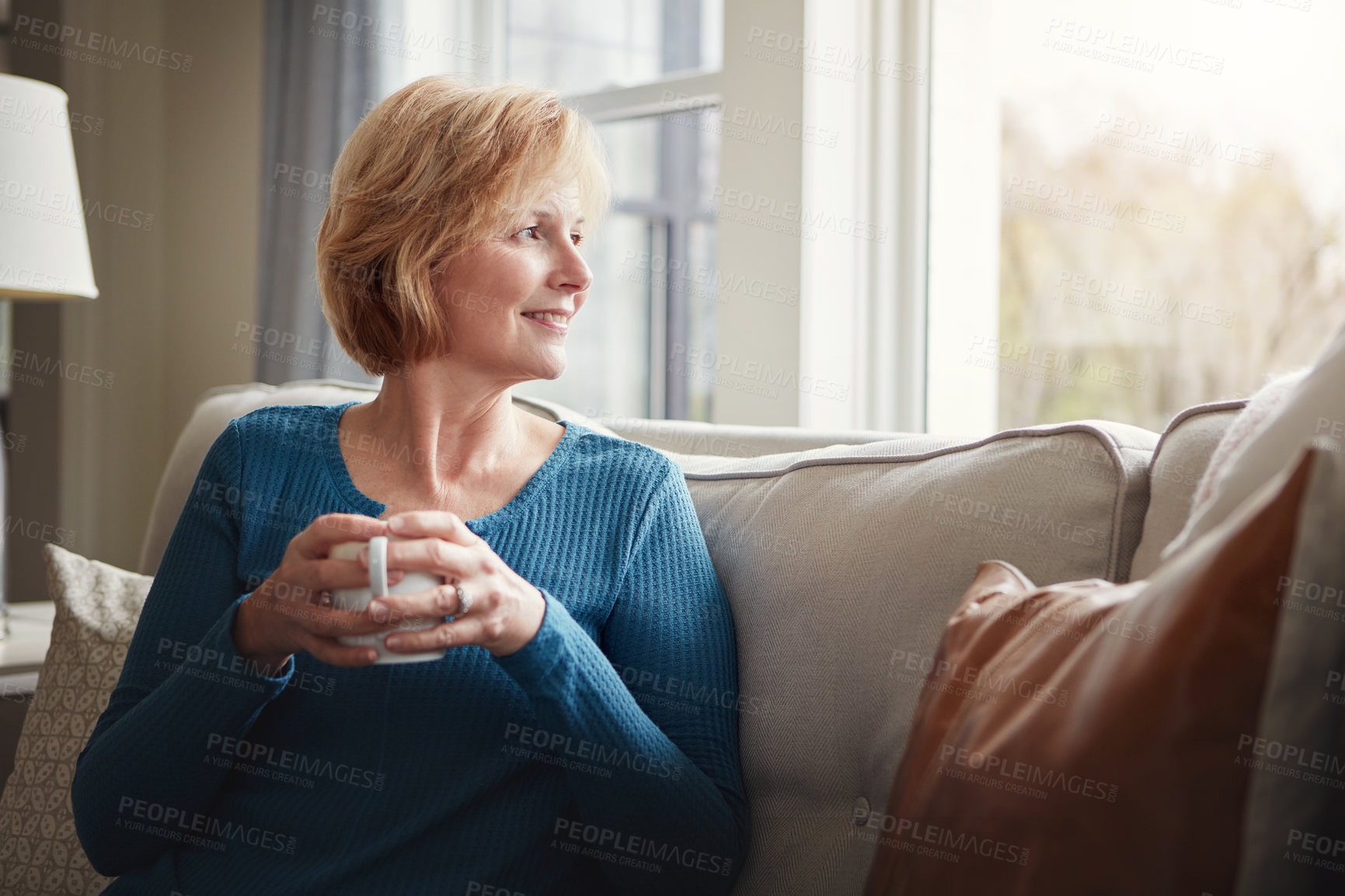 Buy stock photo Relax, thinking and senior woman with coffee on a sofa for peace, reflection and nostalgia with window view. Remember, smile and elderly female person with tea in living room with morning memory