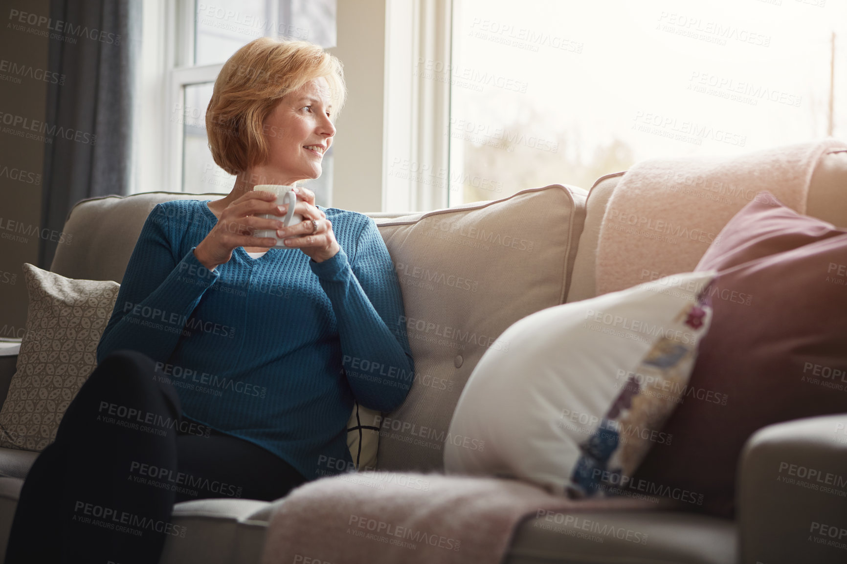 Buy stock photo Thinking, calm and senior woman with coffee on a sofa for peace, reflection and nostalgia, relax or window view. Remember, smile and elderly person with tea in home living room with morning memory