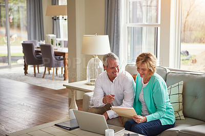 Buy stock photo Senior couple, documents and finance on sofa with laptop, point and talk for profit in home. Old man, woman and computer with paperwork for compliance, happy and investment report for budget review