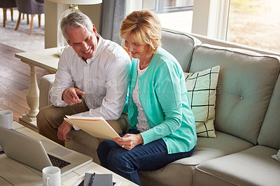 Buy stock photo Senior couple, documents and finance on couch with laptop, point and talk for profit in home. Old man, woman and computer with paperwork for compliance, happy and investment report for budget review