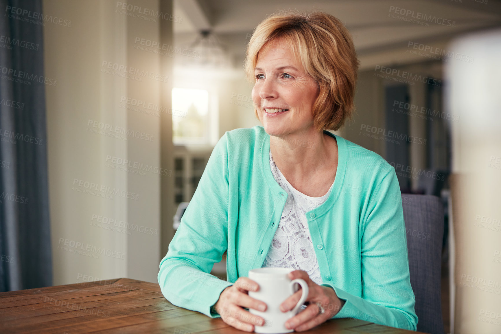 Buy stock photo Shot of a mature woman looking thoughtful while relaxing at home