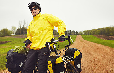 Buy stock photo Cropped shot of a male cyclist enjoying a bike ride on a wet winter's morning