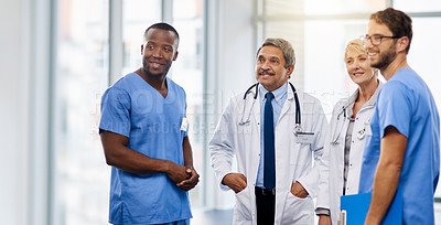 Buy stock photo Team of happy doctors having a group discussion about professional healthcare together in a hospital. Friendly young and mature medical workers standing together smiling after a successful treatment