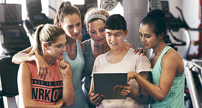 Buy stock photo Cropped shot of a group of young women looking at a digital tablet in the gym