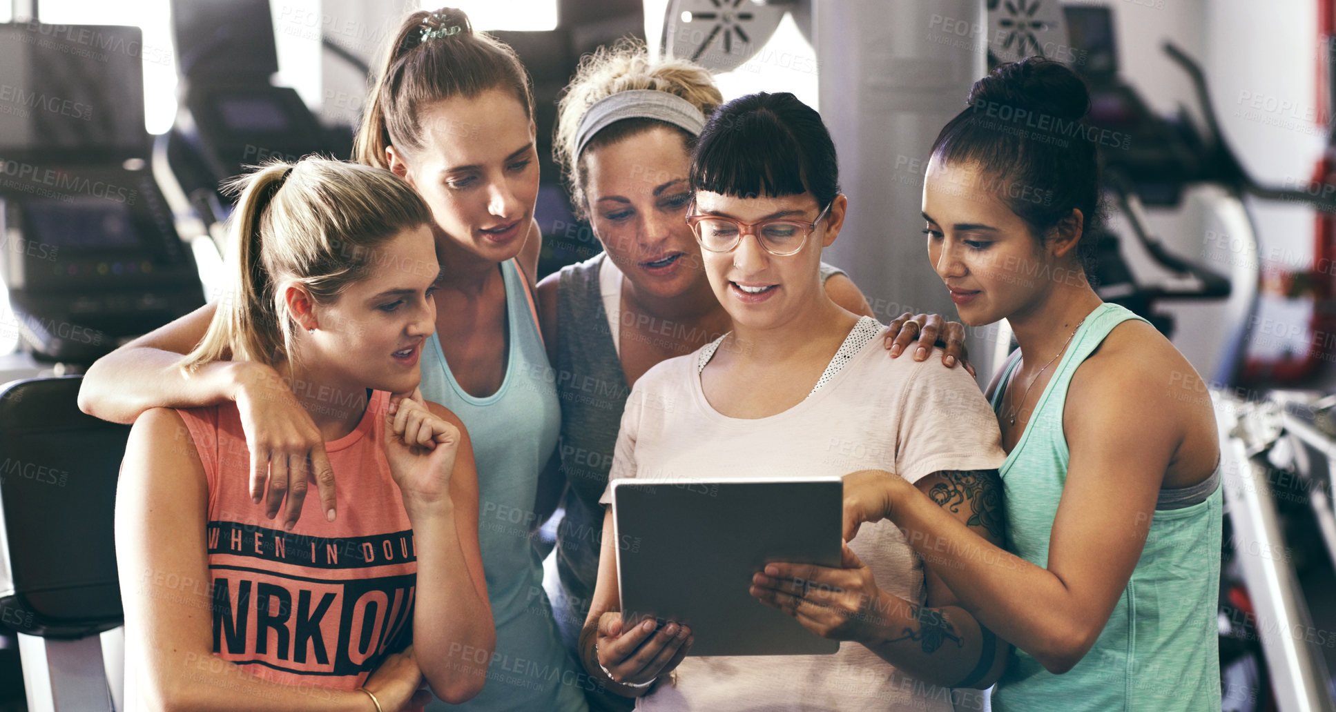 Buy stock photo Cropped shot of a group of young women looking at a digital tablet in the gym