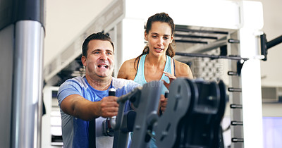 Buy stock photo Cropped shot of a female fitness instructor taking her male client through a workout in the gym