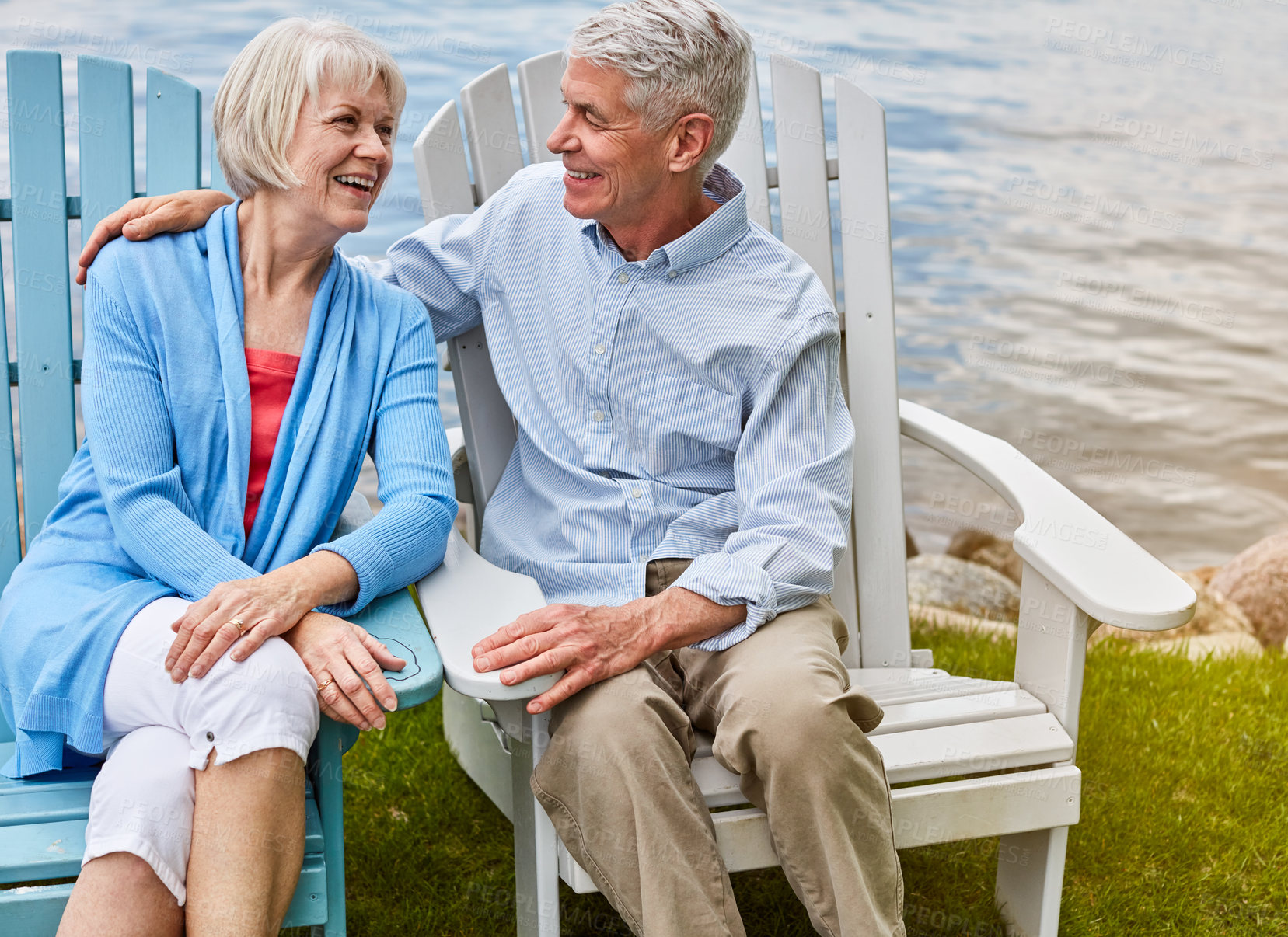 Buy stock photo Shot of an affectionate senior couple relaxing on chairs together outside