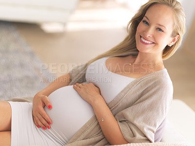 Buy stock photo High angle portrait of a beautiful young pregnant woman sitting on the sofa at home