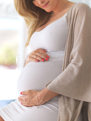 Buy stock photo Cropped shot of an unrecognizable pregnant woman sitting down home
