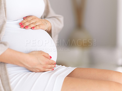 Buy stock photo Cropped shot of an unrecognizable pregnant woman sitting down home