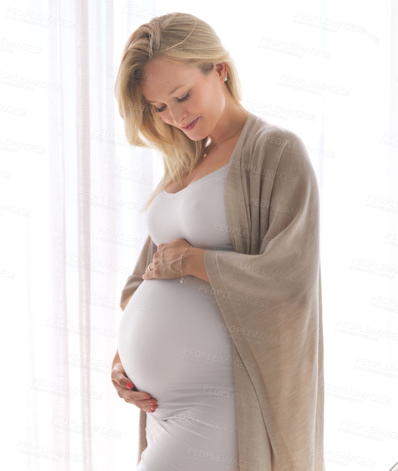 Buy stock photo Cropped shot of a beautiful young pregnant woman standing in her home