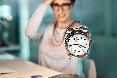 Buy stock photo Shot of a young businesswoman holding a clock worrying about her deadline at the office