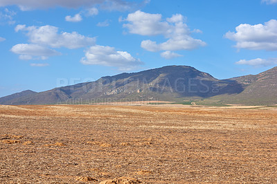 Buy stock photo Farmland in the Western Cape of South Africa in the middle of the day. A mountain in a bare land with a cloudy blue sky. An empty farm with a nature view and a copy space.