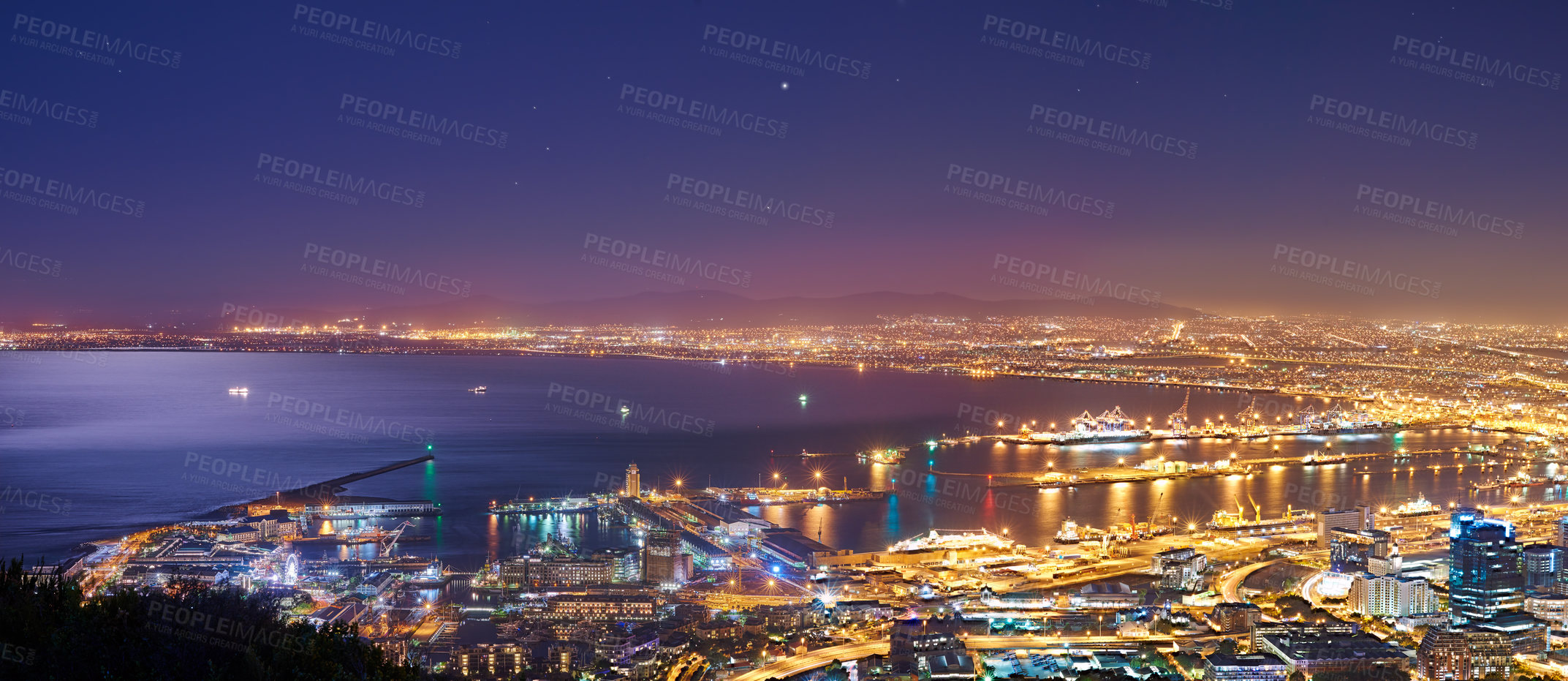 Buy stock photo Scenic landscape view of Cape Town city and harbour lit at night after sunset from Signal Hill, South Africa. Electricity and electrical lights burning in evening with clear blue sky and copy space