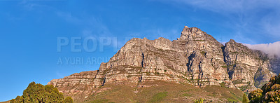 Buy stock photo Low angle panorama of table mountain on a sunny day against a bright blue sky. Scenic landscape of a mountain peak in remote location in Cape Town, South Africa. Wide angle view of nature background