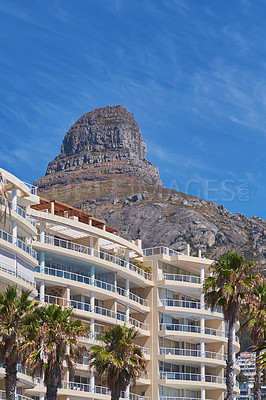 Buy stock photo Copy space of Lions Head in Cape Town South Africa against a blue sky background from below. Panoramic of an iconic landmark and travel destination close to coastal apartment buildings and properties