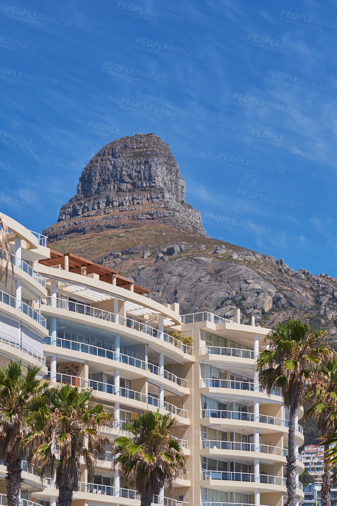 Buy stock photo Copy space of Lions Head in Cape Town South Africa against a blue sky background from below. Panoramic of an iconic landmark and travel destination close to coastal apartment buildings and properties