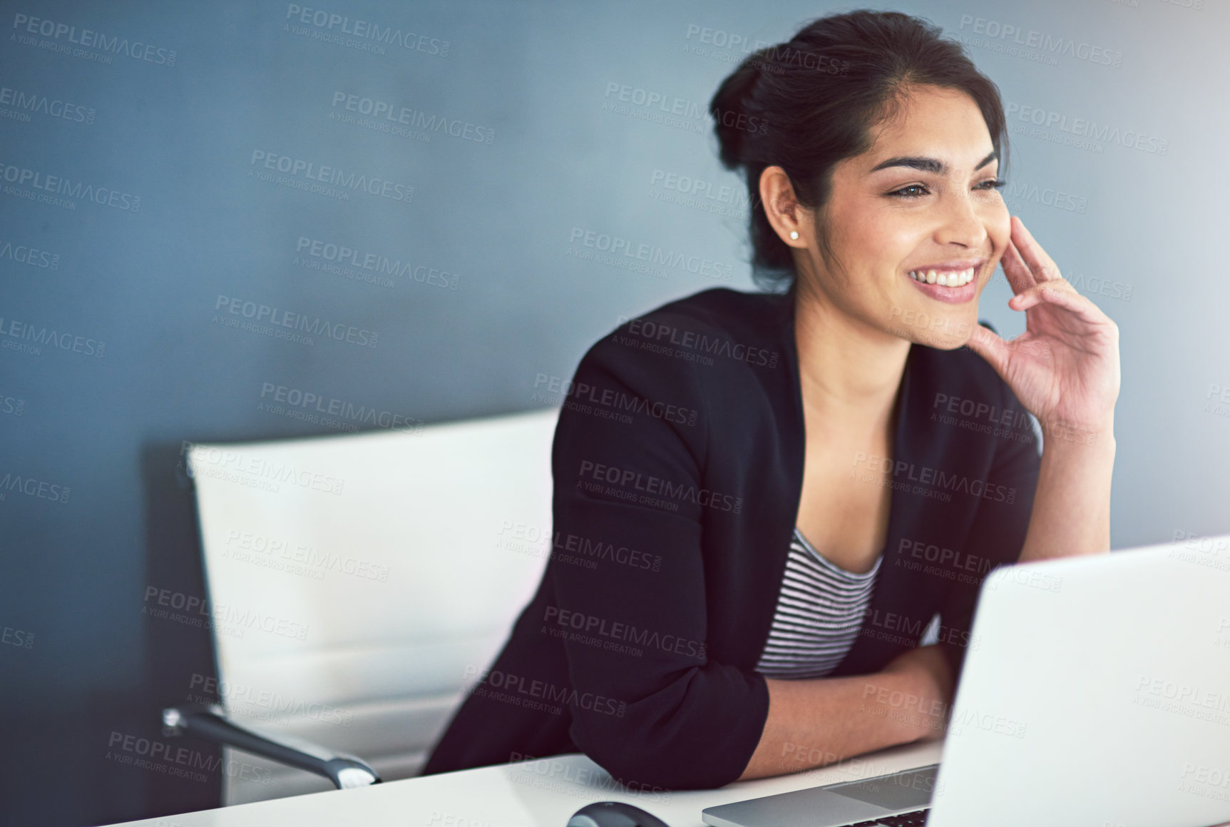 Buy stock photo Cropped shot of an attractive young businesswoman looking thoughtful while working on a laptop in her office
