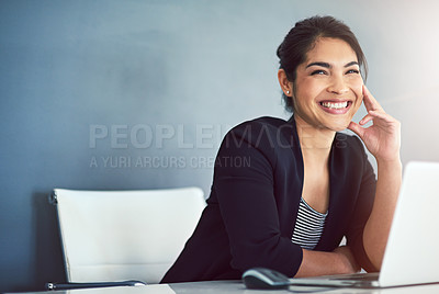 Buy stock photo Cropped shot of an attractive young businesswoman looking thoughtful while working on a laptop in her office