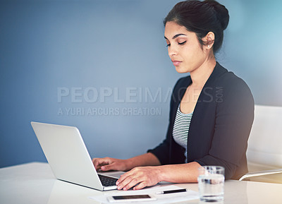 Buy stock photo Cropped shot of an attractive young businesswoman working on a laptop in her office