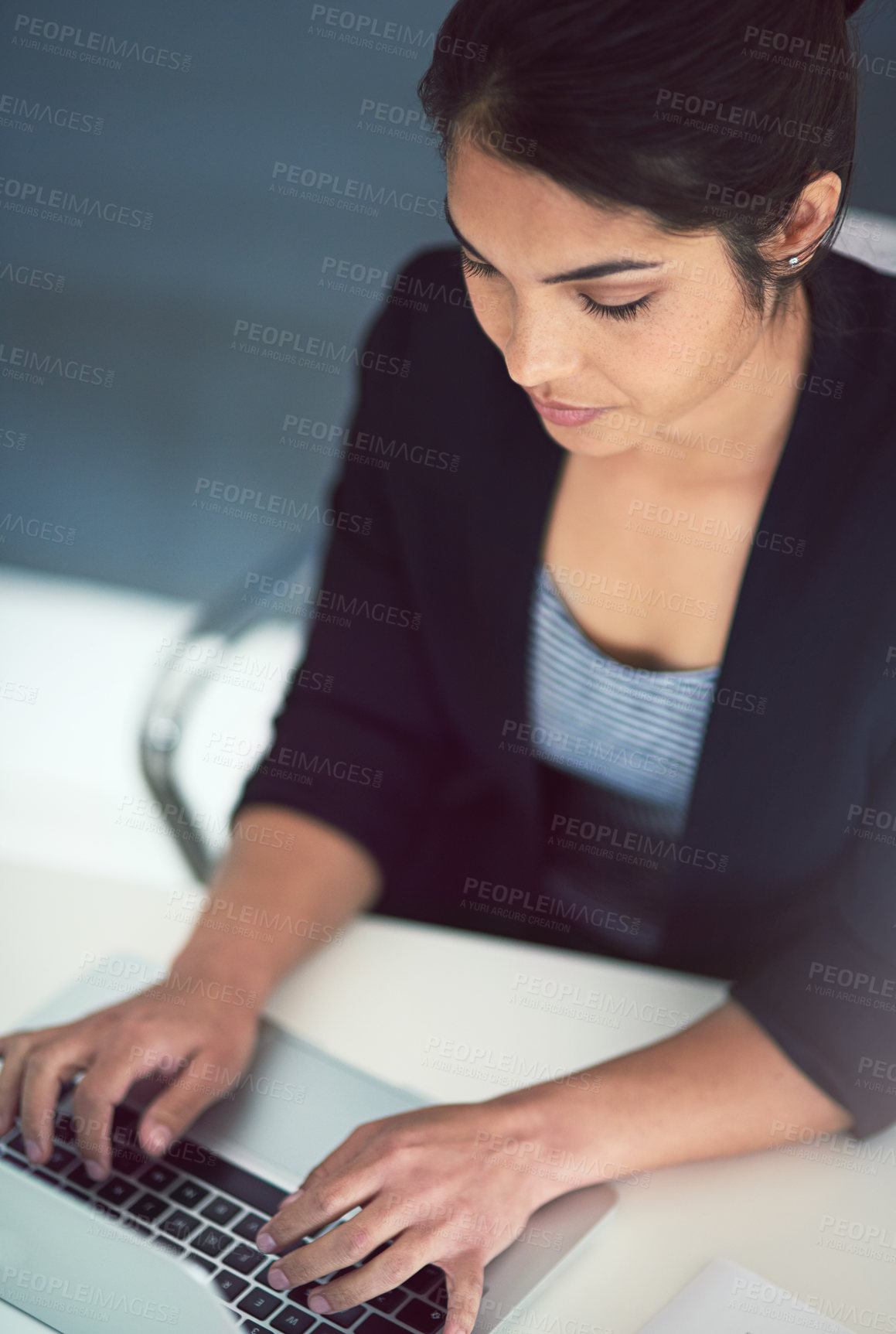 Buy stock photo High angle shot of an attractive young businesswoman working on a laptop in her office