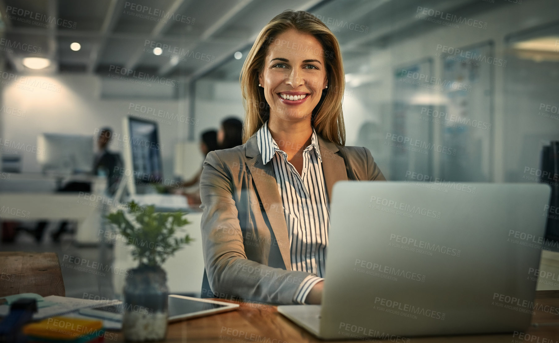 Buy stock photo Portrait of a businesswoman using a laptop during a late shift at work